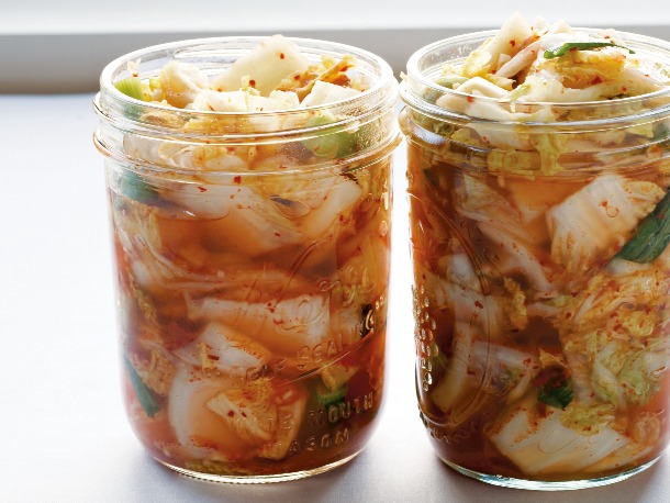 Two jars of kimchi with visible cabbage, spices, and brine, circa 2012